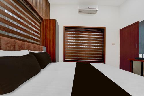 Un dormitorio con una cama grande y una ventana. en Super Townhouse Thondayad Calicut Formerly Dream Casa, en Kakkayam
