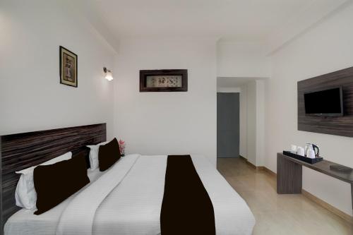 a bedroom with a large bed and a tv at Collection O Vaishno Devi Temple Formerly Hotel The Leaf in Katra