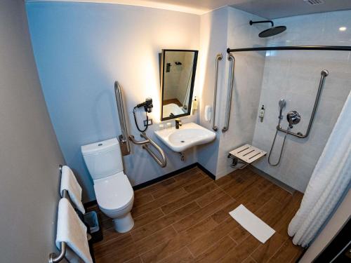 Un baño con inodoro, lavabo y ducha. en ibis styles Lima San Isidro, en Lima