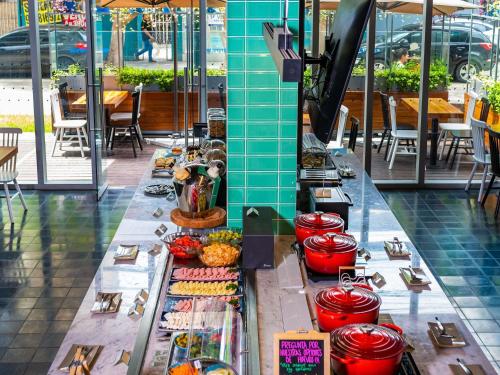 um bufê de comida em uma mesa de restaurante em ibis styles Lima San Isidro em Lima