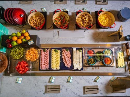 uma mesa com muitos tipos diferentes de alimentos em tigelas em ibis styles Lima San Isidro em Lima