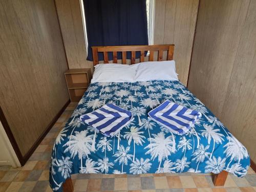 1 cama azul y blanca con 2 almohadas en Jurien Bay View Bungalows Jetty View 5, en Jurien Bay