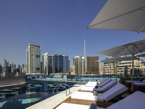 a rooftop pool with a view of a city at Hyde Hotel Dubai in Dubai