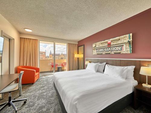 Una habitación de hotel con una cama grande y una silla. en Mercure Perth On Hay, en Perth
