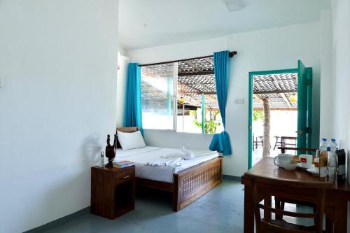 a bedroom with a bed and a table and a window at Ceylon Heart Beach Villa in Galle