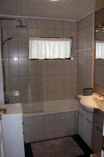 a bathroom with a tub and a sink at Brekkugisting Villa in Blaskogabyggd