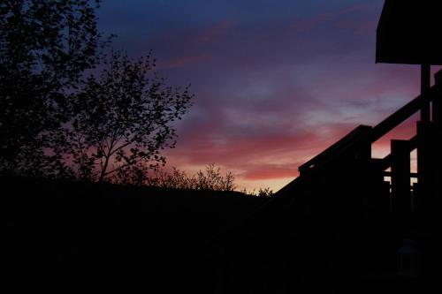 a silhouette of a fence with a sunset in the background at Brekkugisting Villa in Blaskogabyggd