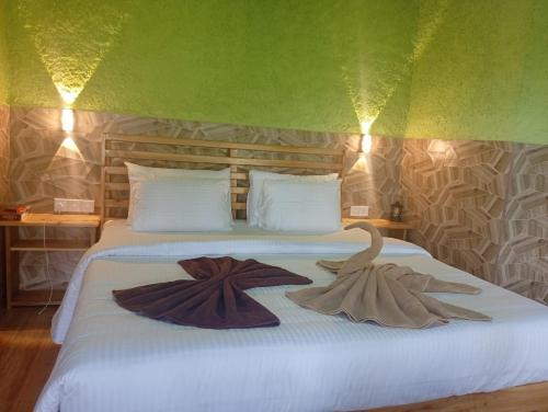 twee zwanen zitten op een bed in een kamer bij NETHSARA cottage in Ella