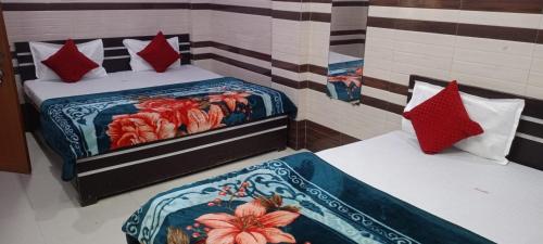 two beds in a room with red pillows at NG Hotal near by Prem mandir in Vrindāvan