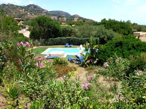 vista sulla piscina in un giardino fiorito di Verde a Santa Margherita di Pula