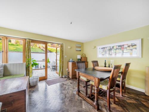 ein Wohnzimmer mit einem Holztisch und Stühlen in der Unterkunft Cider Cottage in Fordingbridge