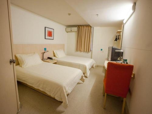 a hotel room with two beds and a television at Jinjiang Inn Shanghai Tongji University in Shanghai