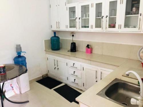 a kitchen with white cabinets and a sink at Castile inn in Puttalam