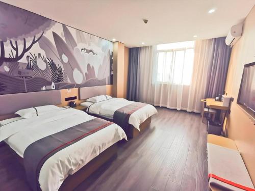 a hotel room with two beds and a painting on the wall at Thank Inn Plus Hotel Jiangyin University in Wuxi