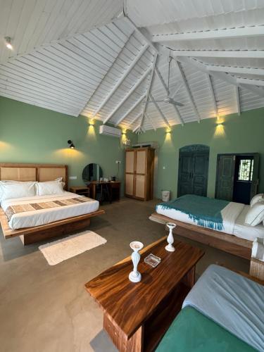 韦利格默Villa Hillcrest Weligama的有两张床和一张桌子的大房间