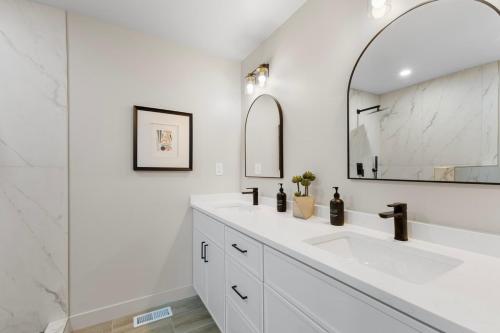 a white bathroom with a sink and a mirror at Centrally Located, Beautiful Park Hill Home in Denver