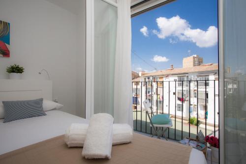 a bedroom with a bed and a balcony with a view at SingularStays Na Jordana in Valencia
