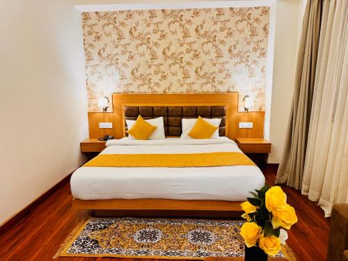 a bedroom with a large bed with yellow pillows at Yeasel Continental Gangtok in Gangtok