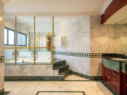 a bathroom with a tub and a sink at Mövenpick Hotel Windhoek in Windhoek