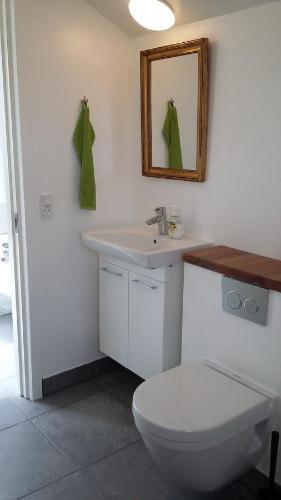 uma casa de banho com um WC, um lavatório e um espelho. em Tikob Go to Sleep em Tikøb