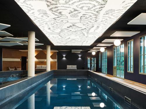 a swimming pool with a ceiling with a mural at TRIBE Hôtel Le Touquet in Le Touquet-Paris-Plage