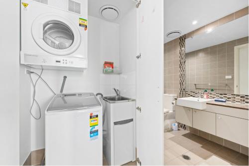 贝尔康嫩Modern 1bed Apartment with Resort-Style Amenities的带洗衣机和水槽的白色浴室