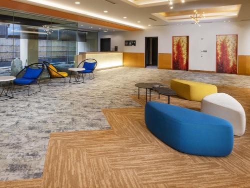 a lobby with chairs and tables in a building at ibis Styles Kyoto Shijo in Kyoto