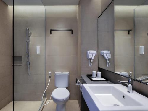 a bathroom with a toilet and a sink and a shower at ibis Surabaya Tidar in Surabaya