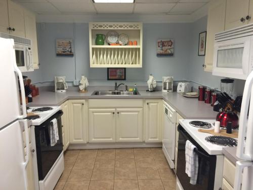 a kitchen with white cabinets and a sink at Riverview Resort in South Yarmouth