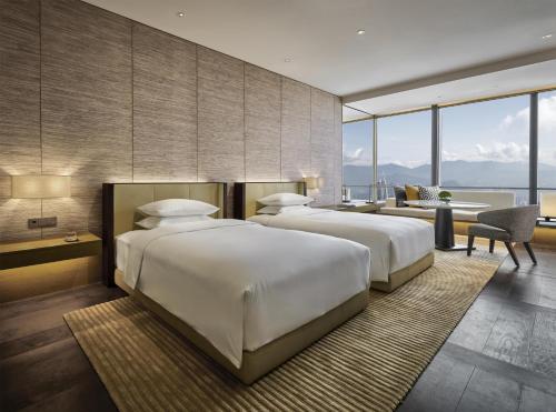 two beds in a hotel room with a view at Park Hyatt Kuala Lumpur in Kuala Lumpur