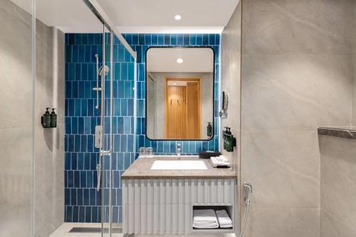 a bathroom with a sink and a mirror at Ramada Encore by Wyndham Rajbagh Srinagar in Srinagar