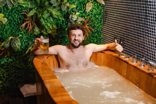 a man in a bath tub with a beer at Hanoi Lion Boutique Hotel & Spa in Hanoi