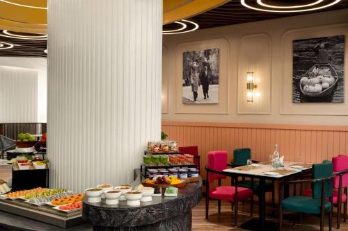 uma sala de jantar com uma mesa com comida sobre ela em Ramada Encore by Wyndham Rajbagh Srinagar em Srinagar