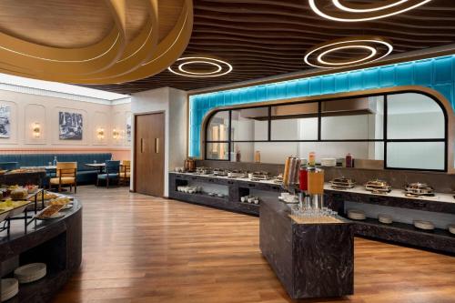 um restaurante com um buffet com um grande espelho em Ramada Encore by Wyndham Rajbagh Srinagar em Srinagar