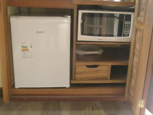 a refrigerator in a cabinet next to a microwave at Paraty Villa d`agua Temporada in Paraty