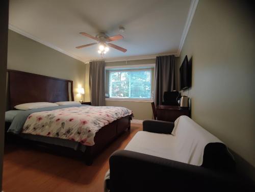 Un dormitorio con una cama y un ventilador de techo. en 3cats, en Burnaby