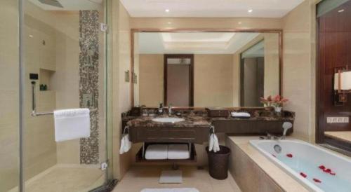 Un baño con bañera, lavabo y bañera. en Howard Johnson Zunyue Hotel Chengdu, en Chengdú
