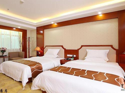 a hotel room with two beds in a room at Borrman Hotel Guangzhou Tianhe Tangdong Subway Station Convention and Exhibition Center in Guangzhou