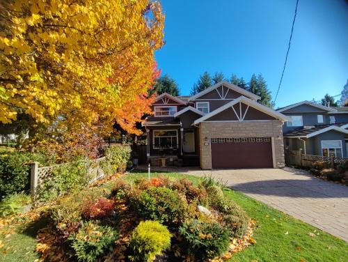 a house with a garage in a yard at Three Kittens Guesthouse in Burnaby