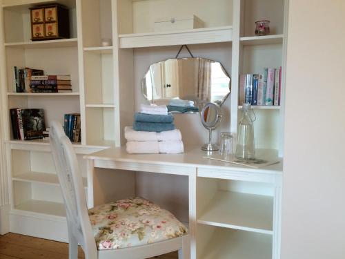 a white desk with a chair and a mirror at Brook Lodge in Glenties