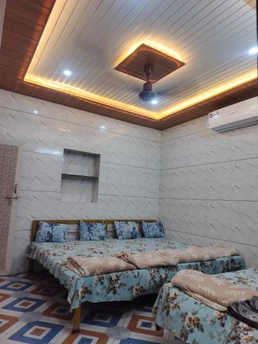 a bedroom with two beds in a room with a ceiling at New brahmani Bhavan in Dwarka