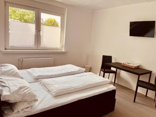 a bedroom with a bed and a desk and a television at Apartment-am-Burgberg, Harztor in Harztor