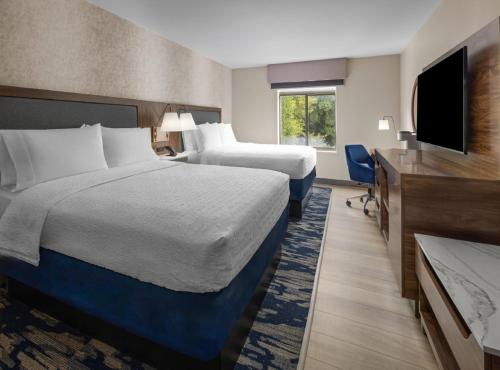a hotel room with two beds and a flat screen tv at Hampton Inn & Suites Richmond Glenside in Richmond