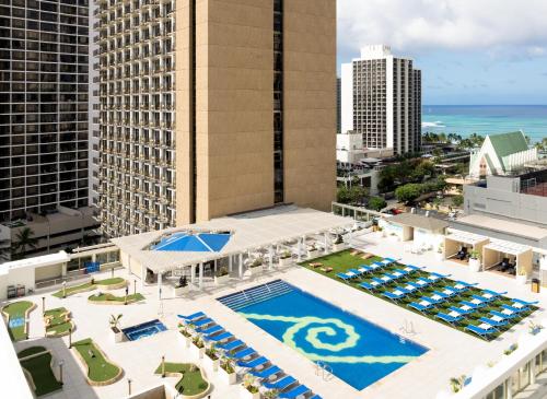 an aerial view of a hotel with a pool and buildings at Hilton Waikiki Beach Resort & Spa in Honolulu