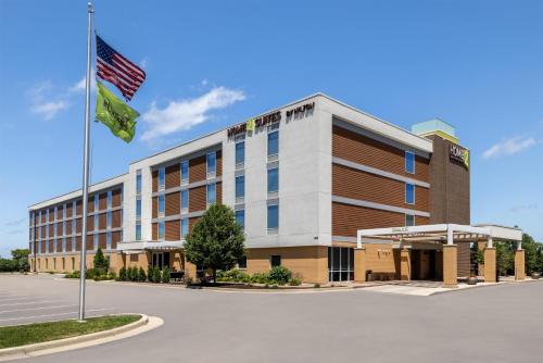 an office building with a flag in front of it at Home2 Suites by Hilton Milwaukee Brookfield in Waukesha