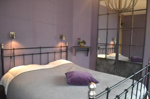 a bedroom with a bed and a large mirror at Maison D'ide in Bouillon