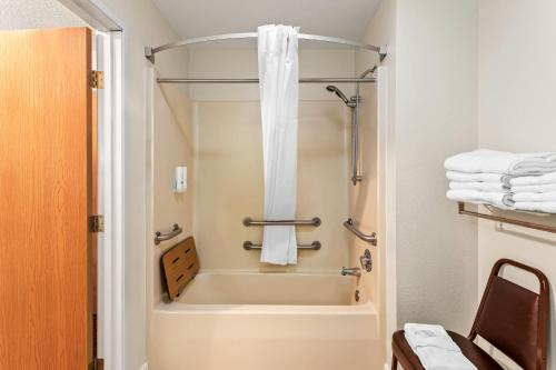 ein Bad mit einer Badewanne und einer Dusche mit Handtüchern in der Unterkunft Quality Inn in Sawyer