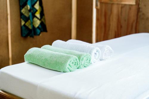 three towels sitting on top of a bed at Kanga Beach Paradise in Mafia Island