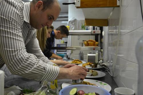 a group of people preparing food in a kitchen at Ezüstfenyő Hotel in Telkibánya