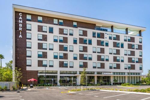 Un hotel con un estacionamiento enfrente. en Cambria Hotel Orlando near Universal Theme Parks, en Orlando